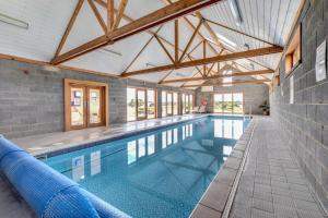 a large swimming pool in a building with a ceiling at 2 Bed in Blythburgh oc-w42765 in Blyford