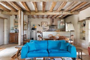 a living room with a blue couch and a table at Le Trianon Isabelle de Maillé - in Cravant-les-Coteaux