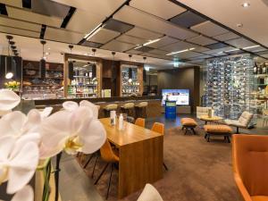 a restaurant with tables and chairs and a bar at Novotel Lugano Paradiso in Lugano