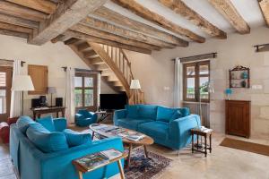 a living room with blue couches and a table at Le Trianon Isabelle de Maillé - in Cravant-les-Coteaux