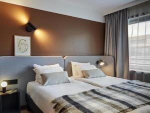 ein Hotelzimmer mit zwei Betten und einem Fenster in der Unterkunft Aparthotel Adagio Paris Bercy Village in Paris