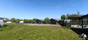 a yard with a fence and some houses at Camping Amable in Someren