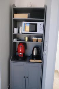 a kitchen with a counter with a microwave and appliances at Nel Corso del Sogni Sicily Center Rooms in Campofelice di Roccella