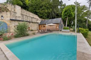 a large blue swimming pool in front of a building at Le Trianon Isabelle de Maillé - in Cravant-les-Coteaux