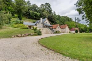 a house on a hill with a gravel driveway at Le Trianon Isabelle de Maillé - in Cravant-les-Coteaux