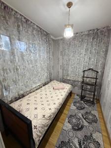 a small bedroom with a bed and a chair at Guest House ak orgo in Bishkek +5 photos