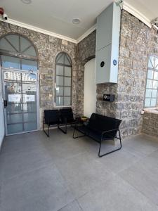 a living room with chairs and a stone wall at City Stay Tiberias - סיטי סטיי טבריה in Tiberias +17 photos