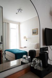 a hotel room with a bed and a mirror at Hotel Excelsior Bay in Malcesine