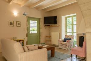 a living room with two chairs and a tv at Villa Verde Petra in Rethymno