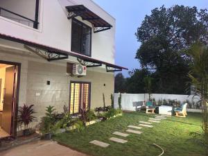 a backyard of a house with a patio and a lawn at JSP OLIVE NEST villa in Yelagiri +3 photos