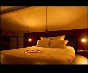 a bedroom with a white bed with lights on it at Ruelle Sensuelle in Ruelle-sur-Touvre