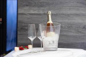 a bottle of wine in a glass next to two wine glasses at Ruelle Sensuelle in Ruelle-sur-Touvre