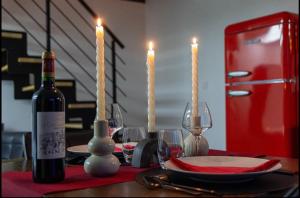 a bottle of wine sitting on a table with candles at Ruelle Sensuelle in Ruelle-sur-Touvre