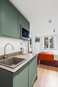 a kitchen with a sink and a bed in a room at Upper Victoria in London +42 photos