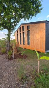 a small wooden house sitting on top of a field at Chalet Ø2 - lumineux et climatisé - proche plage in La Brée-les-Bains