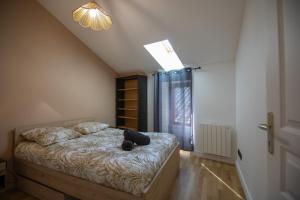a bedroom with a black cat laying on a bed at L'écrin de St Antoine in Saint-Antoine