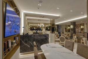 a restaurant with a table and chairs and a television at FEDRA HOTEL in Paralia Katerinis