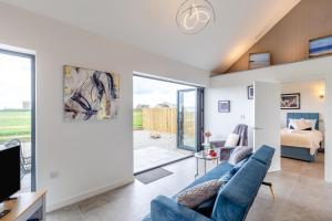 a living room with a blue couch and a bedroom at 2 Bed in Sennen oc-k35172 in Sennen