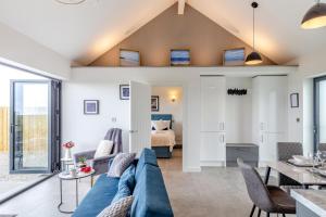 a living room with a blue couch and a bedroom at 2 Bed in Sennen oc-k35172 in Sennen