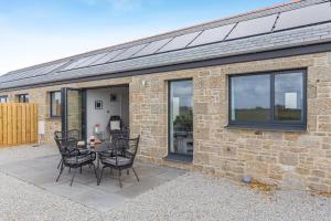 a brick house with a table and chairs on a patio at 2 Bed in Sennen oc-k35172 in Sennen