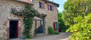 a brick building with roses growing on it at Patissou in Solignac