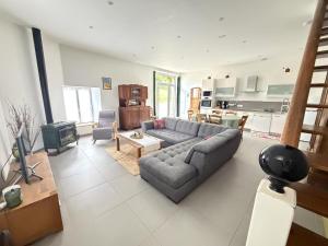a living room with a couch and a kitchen at Patissou in Solignac
