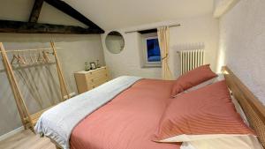a bedroom with a bed with red sheets and a window at Patissou in Solignac +14 photos