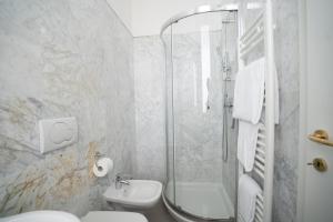 a bathroom with a shower and a toilet and a sink at Hotel Excelsior Bay in Malcesine +16 photos