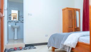 a bedroom with a bed and a bathroom with a sink at Eva Residence Arusha in Arusha +141 photos