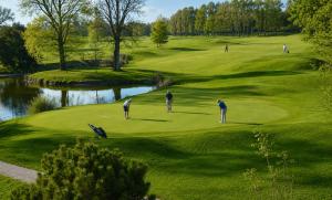 a group of people playing golf on a golf course at L'écrin de St Antoine in Saint-Antoine