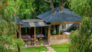 a house with a black roof and a patio at Eva Residence Arusha in Arusha