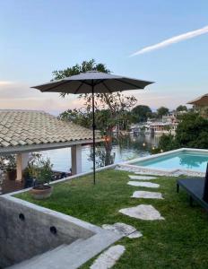 a patio with an umbrella next to a swimming pool at La Calita de Teques in Tequesquitengo