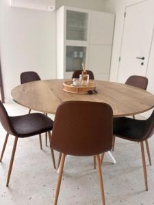 a wooden table with four chairs around it at Maison Lavandelle in Middelkerke