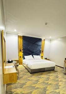 a bedroom with a large bed with a blue headboard at زون آفينيو للشقق المخدومة Zone avenue in Hafr Al-Batin +16 photos