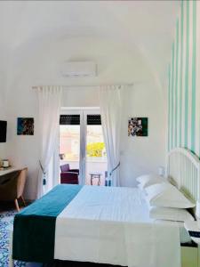 a white bedroom with a bed and a desk at B&B L'Agapanto in Capri +79 photos