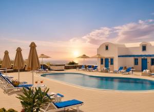 a pool at a resort with chairs and umbrellas at White Pearl Laokasti Suites in Oia