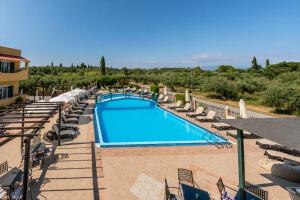 a swimming pool with lounge chairs and a resort at Nikos Villas - Poolside Getaways in Kavos, Corfu in Kavos