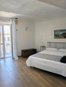 ein Schlafzimmer mit einem weißen Bett und einem großen Fenster in der Unterkunft Appartamento in Monferrato di Dominga in Portacomaro + 22 Fotos