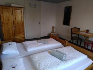 two twin beds in a room with a table at Gästewohnung am Sternberg in Gomadingen