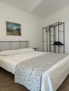 ein Schlafzimmer mit einem großen Bett mit weißer Bettwäsche in der Unterkunft Appartamento in Monferrato di Dominga in Portacomaro