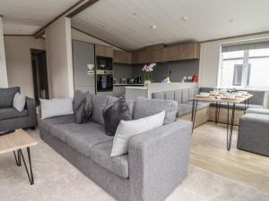 a living room with a couch and a kitchen at Cedar Lodge 3 Bedrooms in Northwich