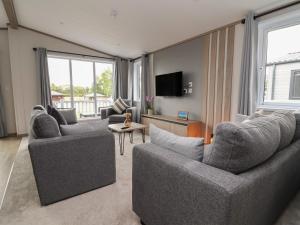 a living room with two couches and a tv at Cedar Lodge 3 Bedrooms in Northwich