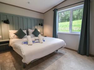 a bedroom with a large white bed with a window at Cedar Lodge 3 Bedrooms in Northwich