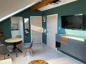 a living room with a table and chairs and a television at Moderne Ferienwohnung mit Balkon und Klima in Neufraunhofen