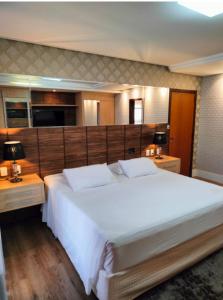 a bedroom with a large white bed and two night stands at GoldMen Business Sorriso in Sorriso +58 photos