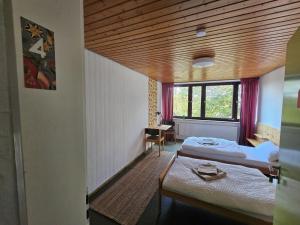 a bedroom with two beds and a wooden ceiling at Gästehaus am Sternberg in Gomadingen