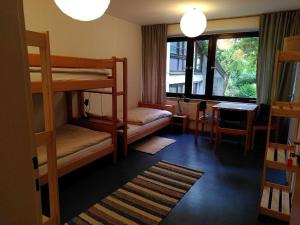 a bedroom with bunk beds and a desk and a window at Gästehaus am Sternberg in Gomadingen