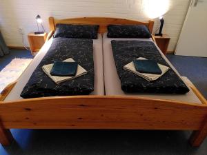 a wooden bed with two beds with napkins on it at Gästehaus am Sternberg in Gomadingen