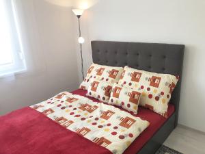 a bed with a black headboard and two pillows at Szende Apartman in Balatonfüred