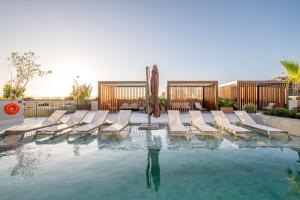 a swimming pool with lounge chairs and an umbrella at Skyline Parque Moinhos by LikeHome in Floresta